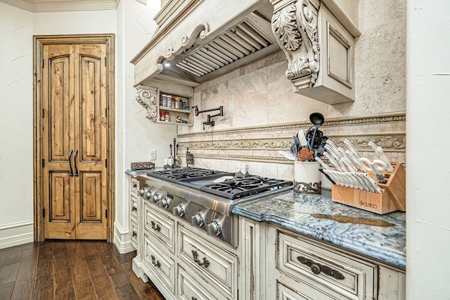 kitchen featuring stainless steel gas stovetop, custom exhaust hood, stone counters, cream cabinets, and dark hardwood / wood-style floors