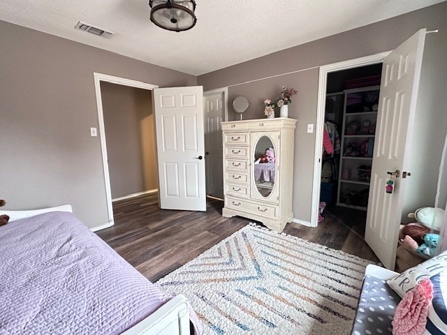 bedroom with dark hardwood / wood-style floors, a closet, and a textured ceiling