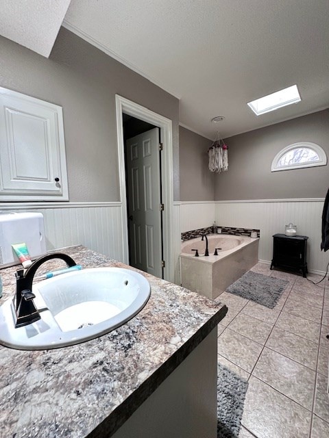 bathroom featuring a skylight, vanity, a washtub, tile patterned floors, and a textured ceiling