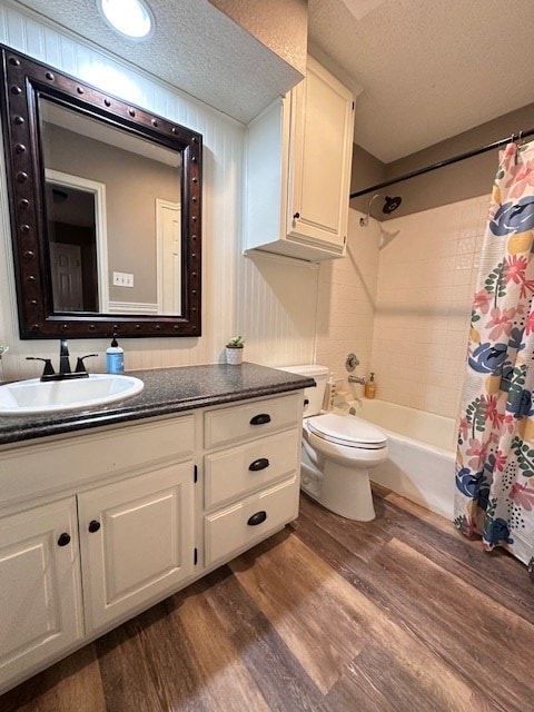 full bathroom featuring shower / tub combo with curtain, toilet, a textured ceiling, vanity, and hardwood / wood-style flooring