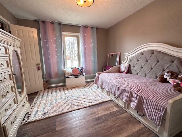 bedroom with dark wood-type flooring and a textured ceiling