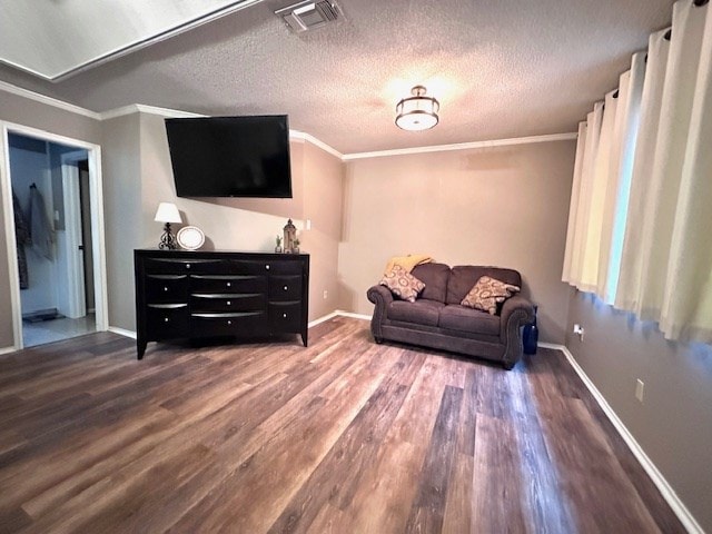 living area with ornamental molding, hardwood / wood-style floors, and a textured ceiling