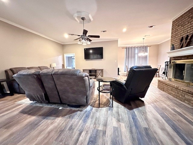 living room featuring ceiling fan, ornamental molding, a fireplace, and hardwood / wood-style floors