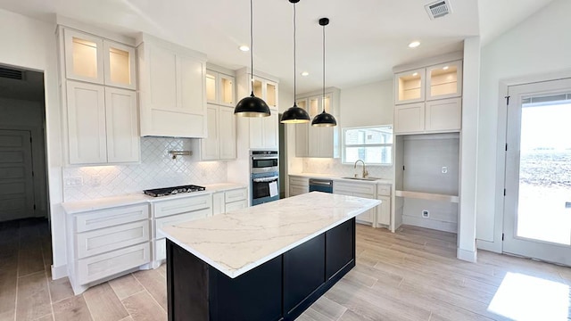 2217 S County Rd 1059, Midland, TX 79706 - kitchen featuring light stone counters, white cabinetry, and glass insert cabinets