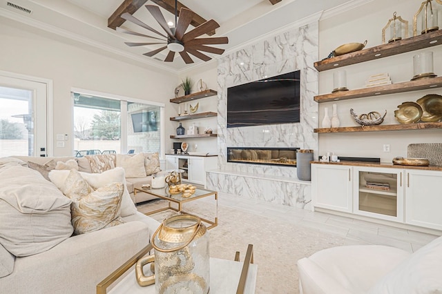 living area featuring visible vents, beamed ceiling, crown molding, and a high end fireplace