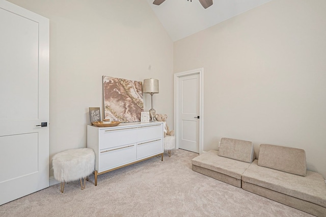 living area with high vaulted ceiling, light colored carpet, and ceiling fan