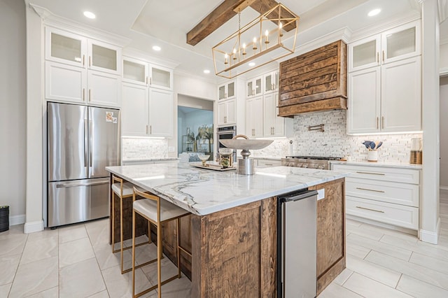 kitchen featuring stainless steel appliances, white cabinetry, an island with sink, glass insert cabinets, and pendant lighting