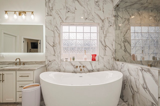 bathroom featuring marble finish floor, a freestanding bath, and vanity