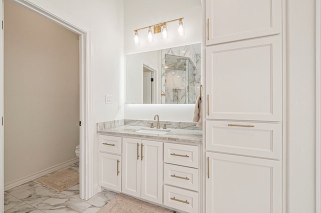 full bathroom with a marble finish shower, baseboards, toilet, marble finish floor, and vanity