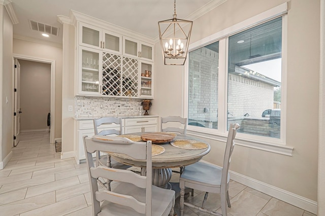 dining area with an inviting chandelier, baseboards, visible vents, and crown molding