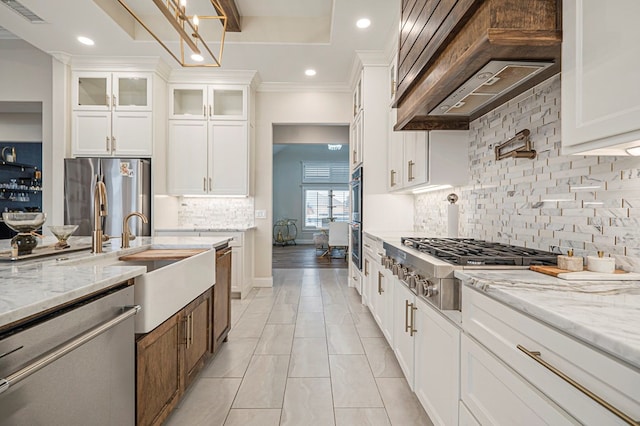 kitchen featuring premium range hood, appliances with stainless steel finishes, glass insert cabinets, and white cabinets