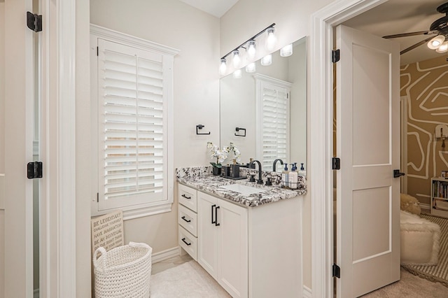 bathroom featuring baseboards, a ceiling fan, and vanity