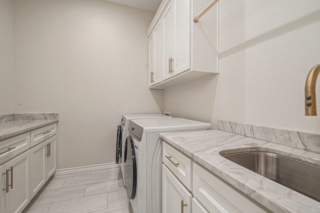 washroom featuring cabinet space, baseboards, and washing machine and clothes dryer