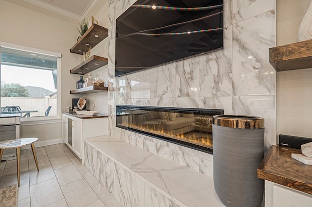 kitchen with a tile fireplace, white cabinetry, open shelves, dark countertops, and crown molding