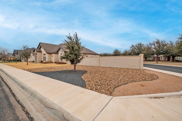 view of front of property featuring a residential view and fence