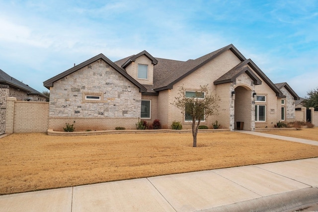 french country inspired facade with brick siding and fence