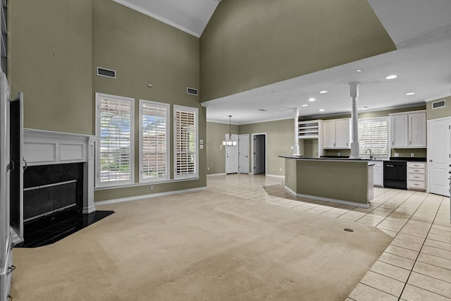 kitchen featuring a premium fireplace, dishwasher, light tile patterned floors, crown molding, and dark countertops