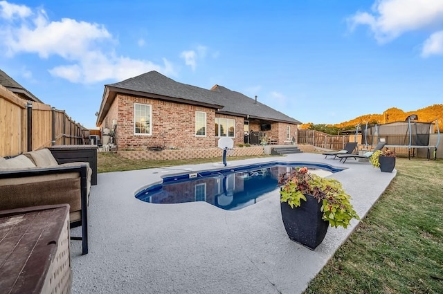 view of swimming pool with a lawn, a patio area, and a trampoline