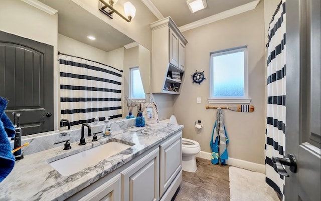 bathroom featuring vanity, toilet, a wealth of natural light, and crown molding