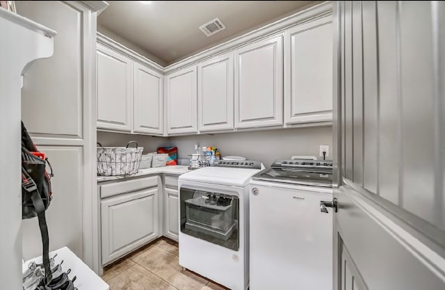 laundry room featuring cabinets and washer and dryer