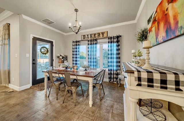 dining room with hardwood / wood-style floors, a notable chandelier, and crown molding