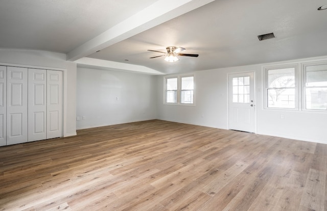 unfurnished living room featuring ceiling fan, beam ceiling, and light wood-type flooring