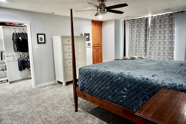 bedroom featuring a closet, baseboards, light colored carpet, a spacious closet, and a ceiling fan