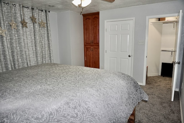 carpeted bedroom featuring baseboards, ceiling fan, and a textured ceiling