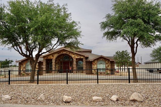 view of front of house featuring a fenced front yard and stone siding