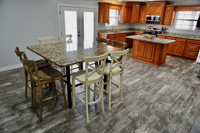 kitchen featuring plenty of natural light, stainless steel microwave, range, and a kitchen island