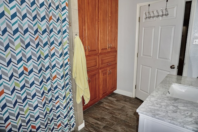 full bath with vanity, baseboards, a shower with curtain, and wood finished floors
