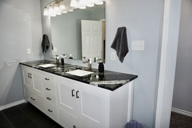 bathroom featuring double vanity, baseboards, a sink, and tile patterned flooring