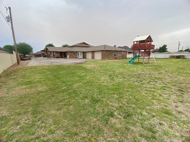 view of yard with a playground and a garage