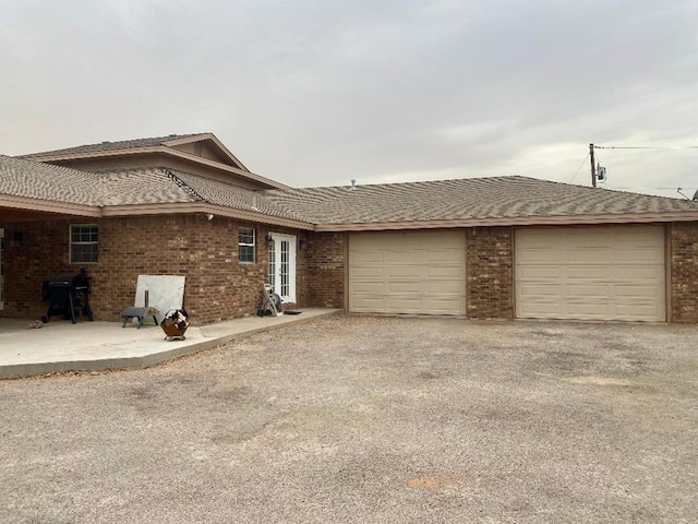 view of side of property with an attached garage, driveway, and brick siding