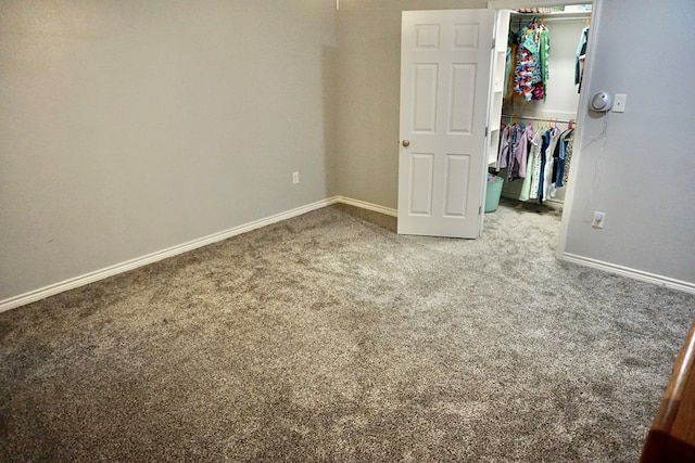unfurnished bedroom featuring baseboards, carpet, a closet, and a walk in closet