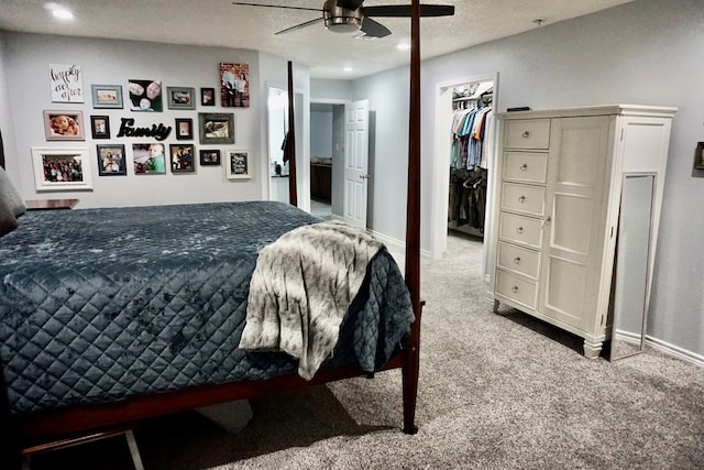 bedroom with a walk in closet, baseboards, carpet flooring, and recessed lighting