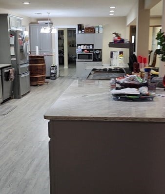 kitchen with a chandelier, kitchen peninsula, stainless steel appliances, and light hardwood / wood-style flooring