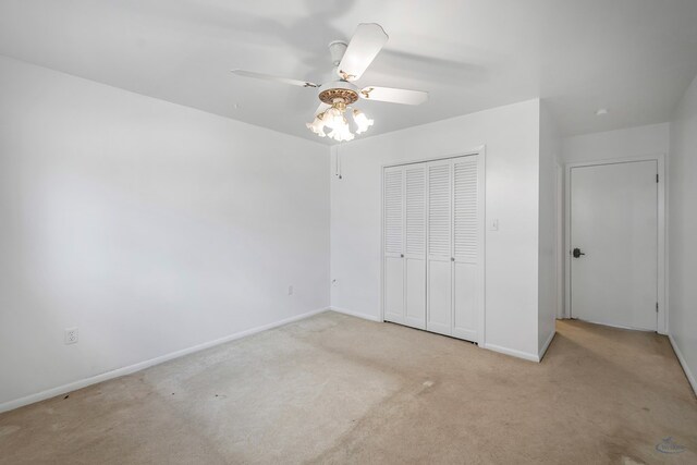 unfurnished bedroom featuring ceiling fan, a closet, and light carpet