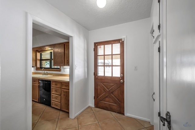 entryway featuring light tile patterned floors, a textured ceiling, and sink