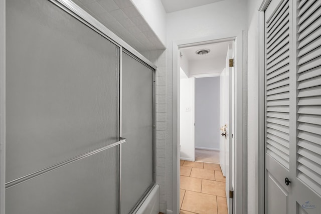 bathroom featuring tile patterned flooring and enclosed tub / shower combo