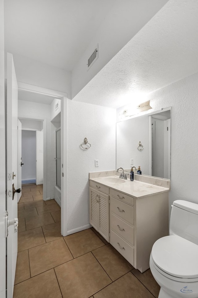 bathroom with tile patterned flooring, vanity, and toilet