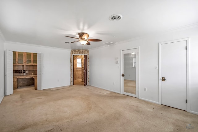 unfurnished bedroom featuring ceiling fan, light colored carpet, ornamental molding, and connected bathroom