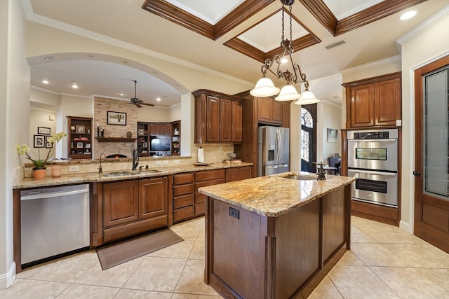 kitchen featuring a kitchen island with sink, sink, stainless steel appliances, and ornamental molding