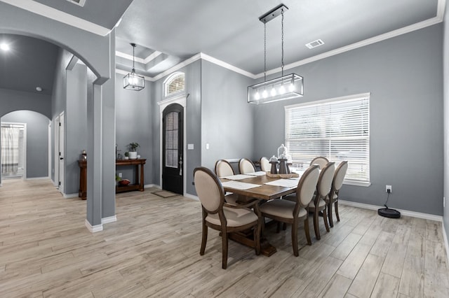 dining space featuring light hardwood / wood-style flooring, an inviting chandelier, and ornamental molding