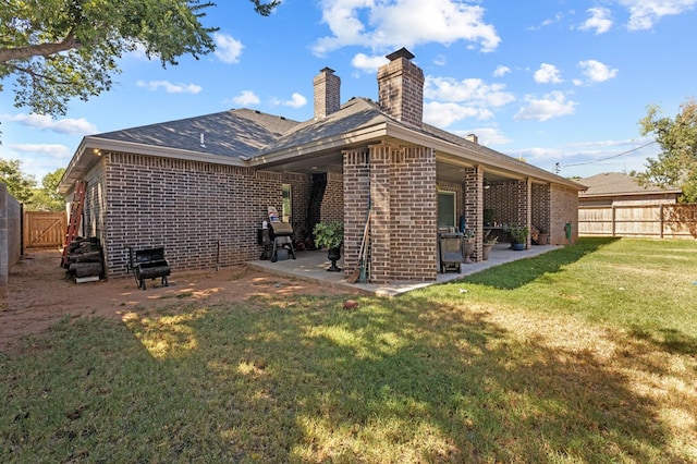 back of property with a lawn and a patio