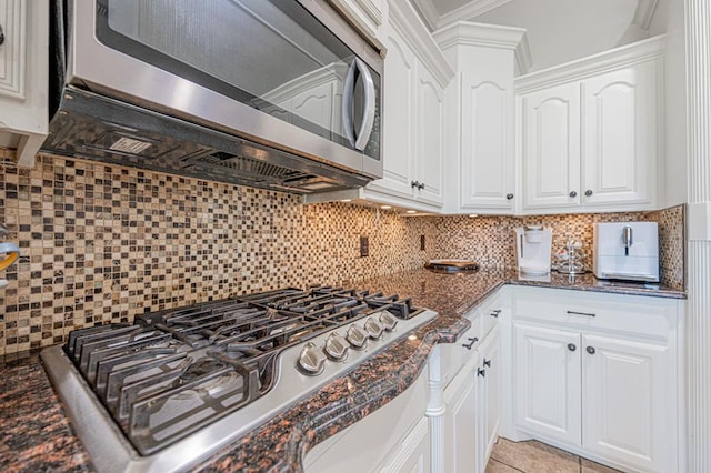 kitchen with tasteful backsplash, dark stone countertops, white cabinets, and stainless steel appliances