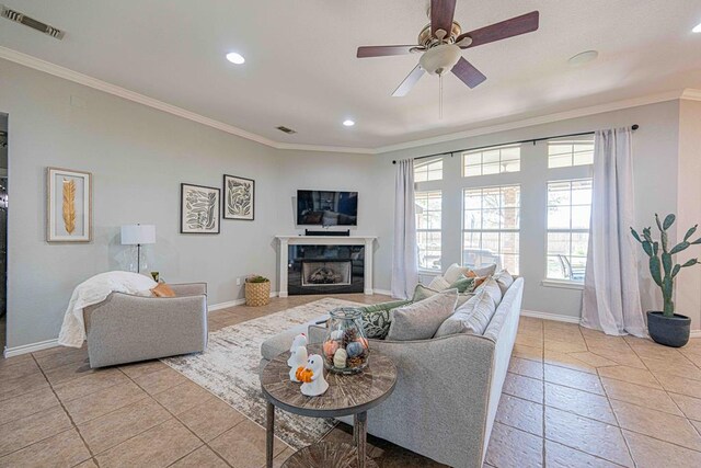 living room featuring ceiling fan, crown molding, and light tile patterned flooring