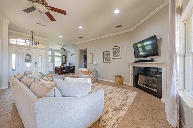 tiled living room featuring ceiling fan and crown molding