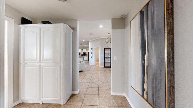 hallway featuring a notable chandelier and light tile patterned flooring