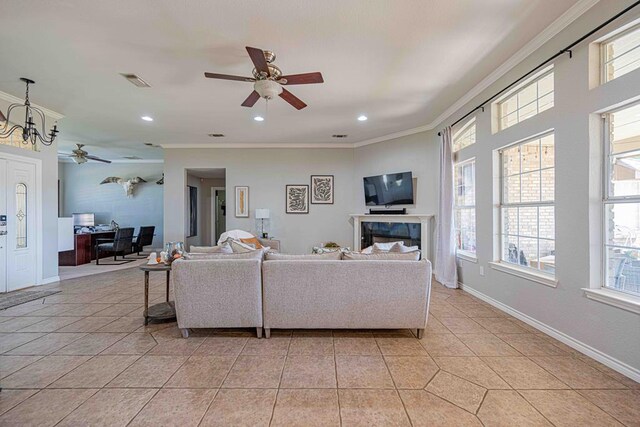 tiled living room featuring crown molding, plenty of natural light, and ceiling fan with notable chandelier